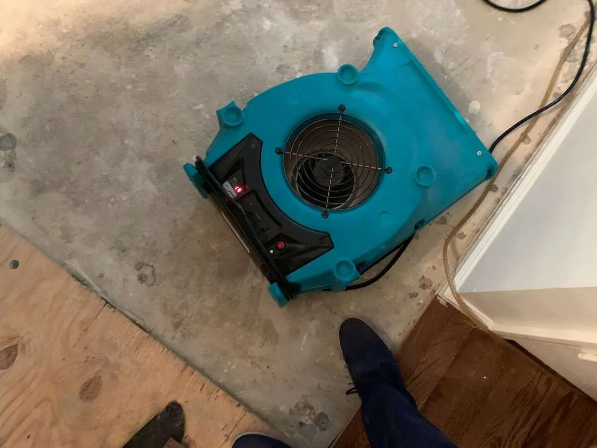 Air mover drying subfloor during Commercial Water Damage Restoration in Glens Falls
